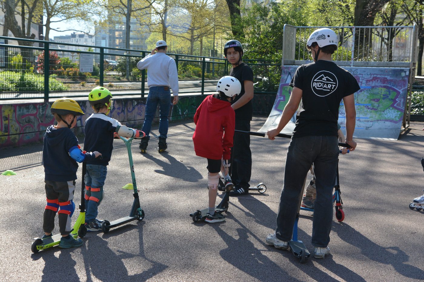 Groupe d'enfants en trottinette autour de leur encadrant en tee-shirt RIDEART